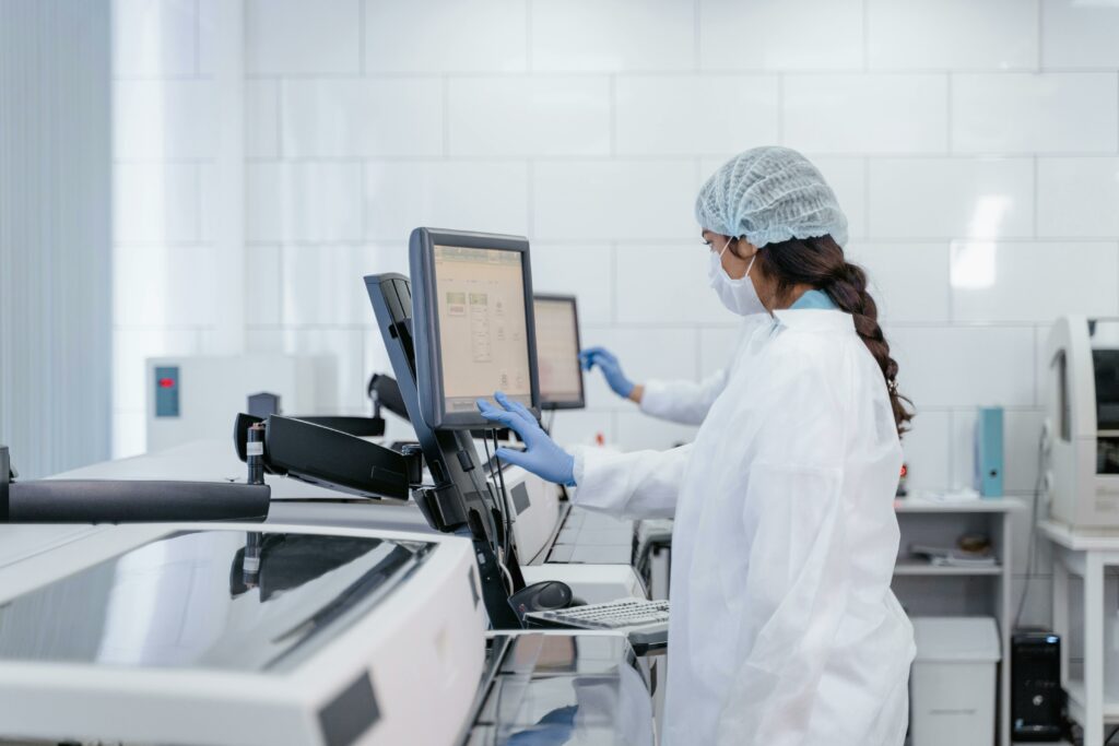 Female scientist in protective gear using lab equipment for research.. Photo by ima Miroshnichenko via Pexels (CC0)